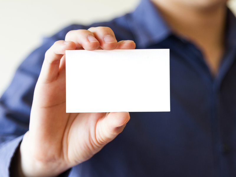 How to come up with a business name - man holding up a blank business card